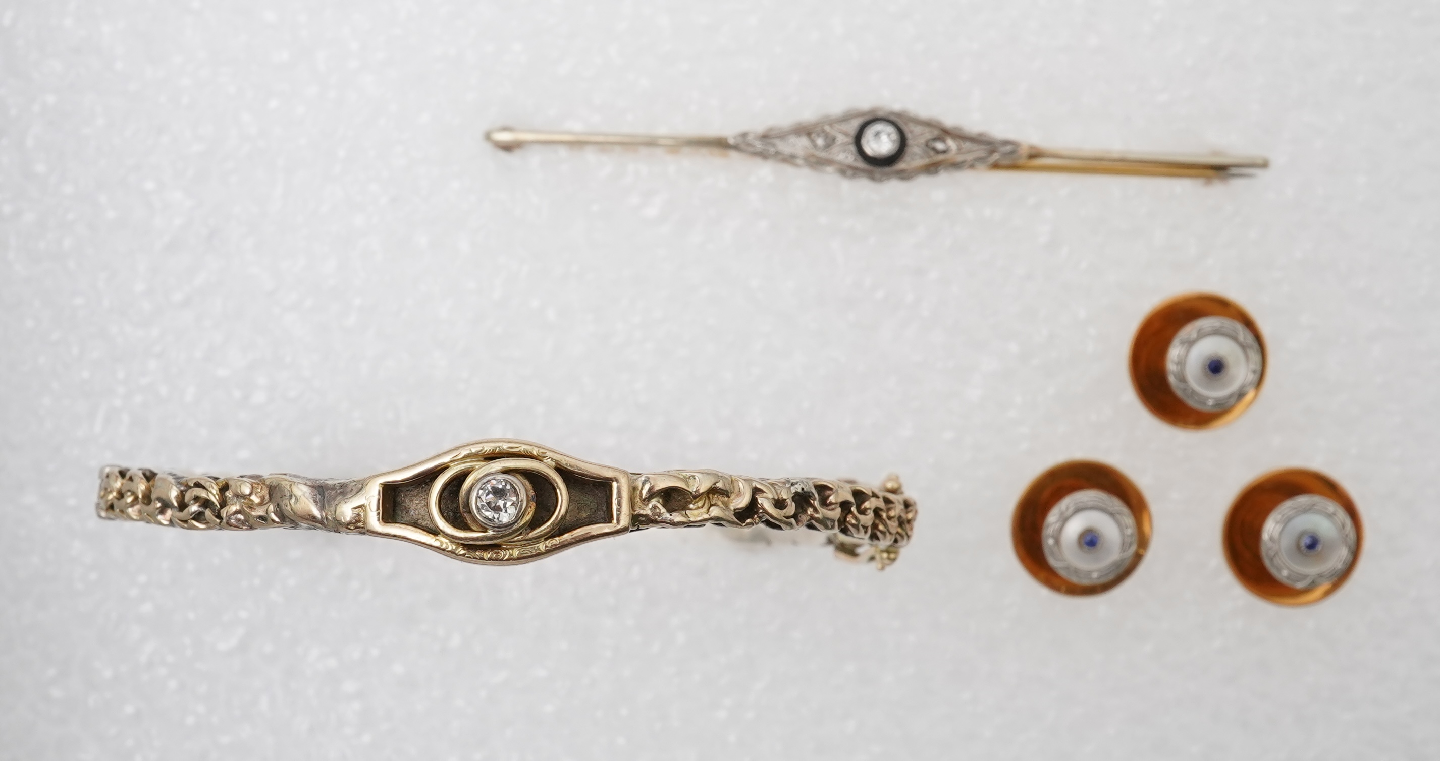 A collection of jewels and accessories, comprising: an onyx and diamond bar brooch, mounted in gold; a bangle set with a circular-cut diamond weighing approximately 0.07 carats, inner circumference approximately 17cm, st